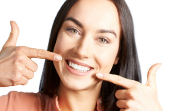 satisfied woman points at her perfect smile